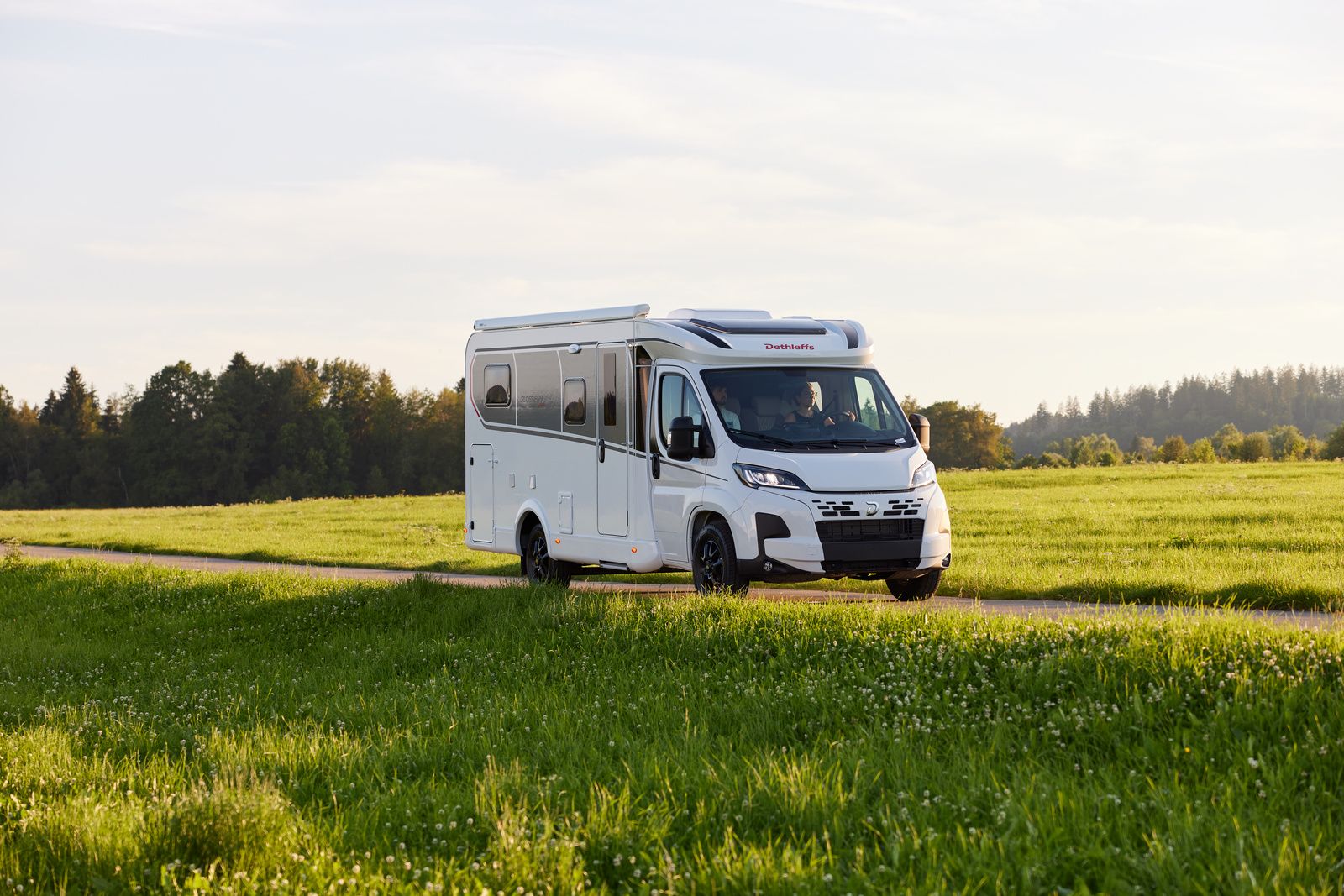 Asuntoauto kesäisen pellon keskellä.