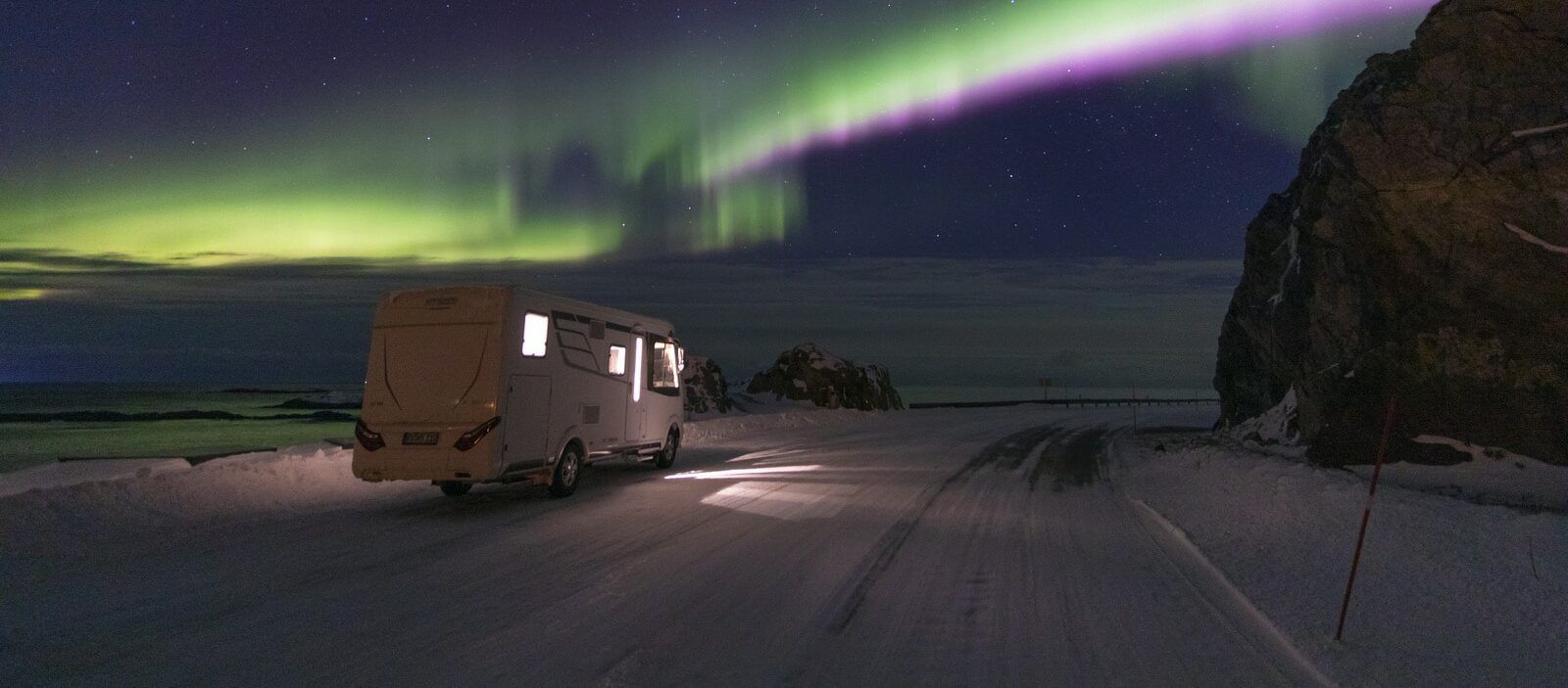 Hymer matkailuauto revontulten alla.